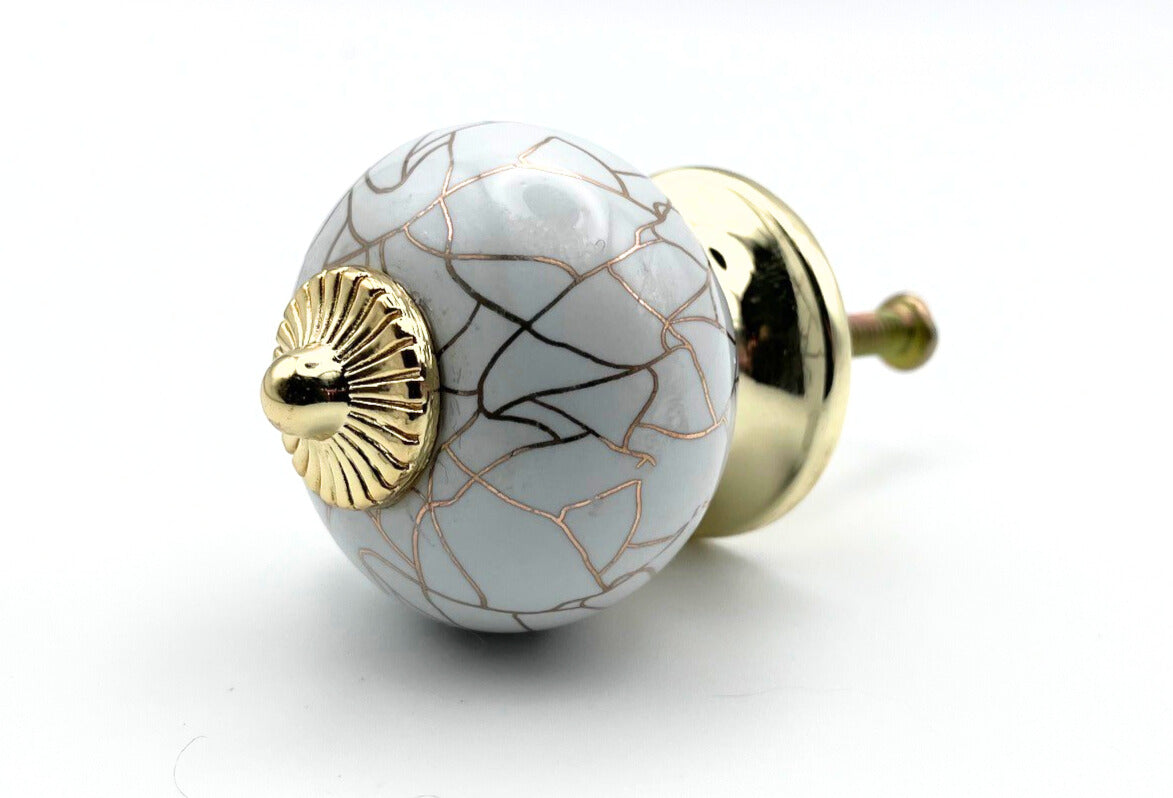 Decorative ceramic knob with gold accents on a white background