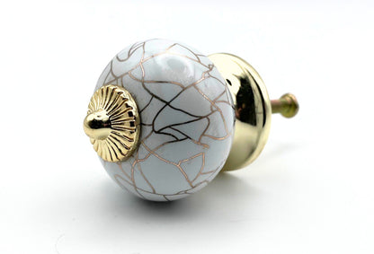 Decorative ceramic knob with gold accents on a white background