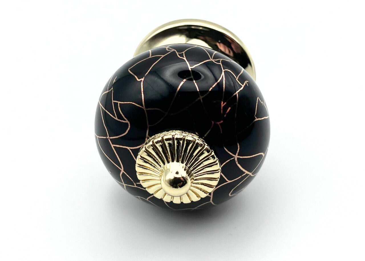 black round shaped knob with rose gold crackle design and gold metal hardware