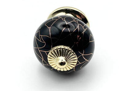 black round shaped knob with rose gold crackle design and gold metal hardware