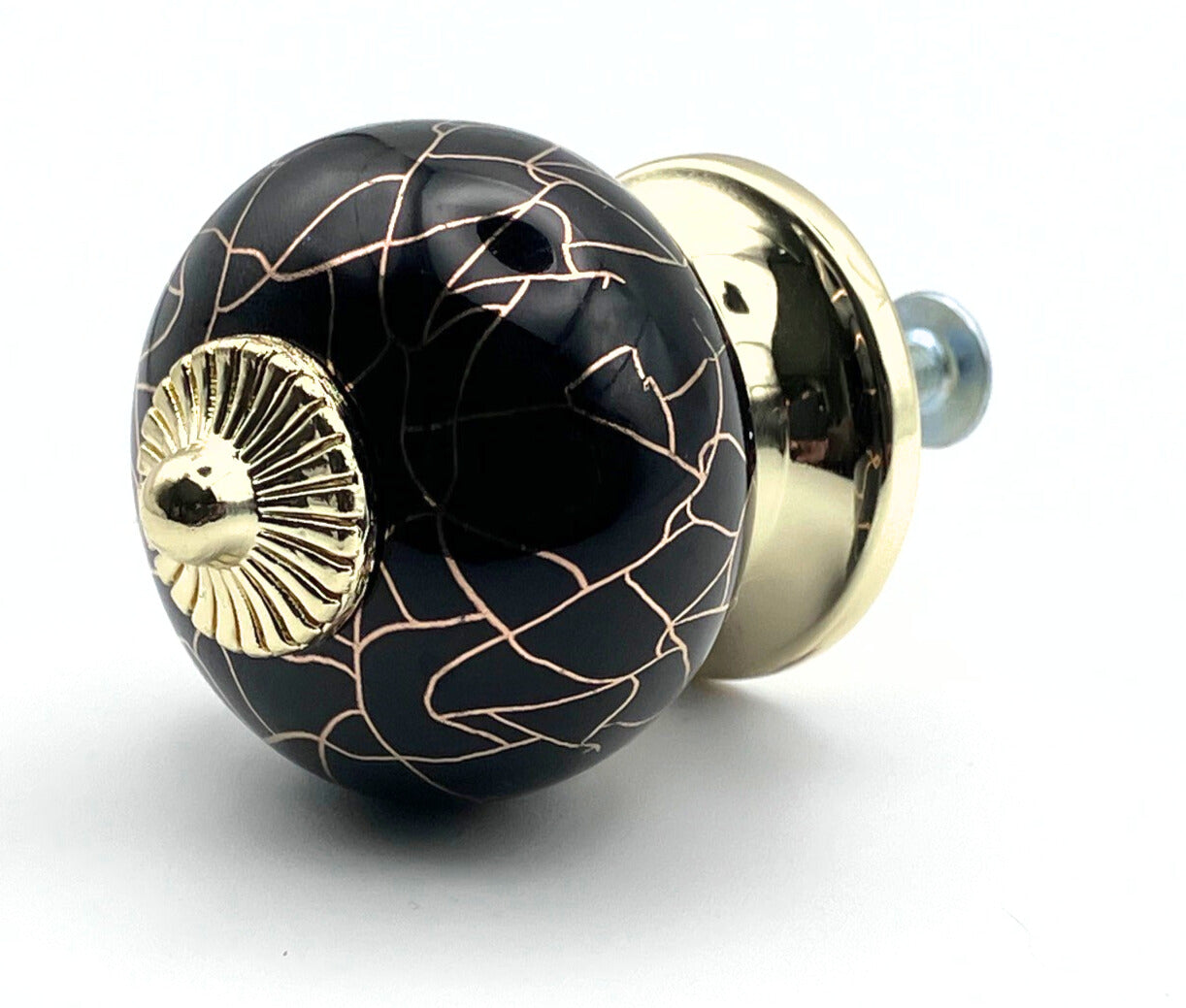 Decorative black and gold knob on a white background