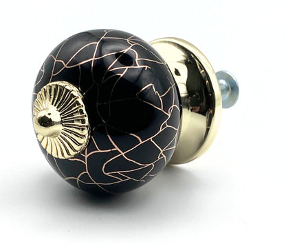 Decorative black and gold knob on a white background