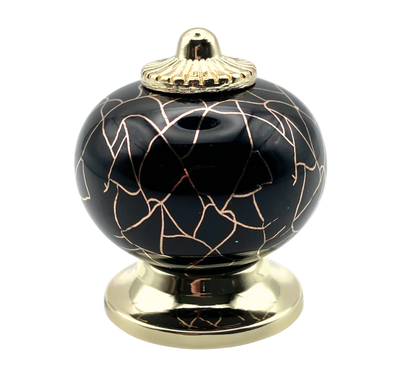 black round shaped knob with rose gold crackle design and gold metal hardware