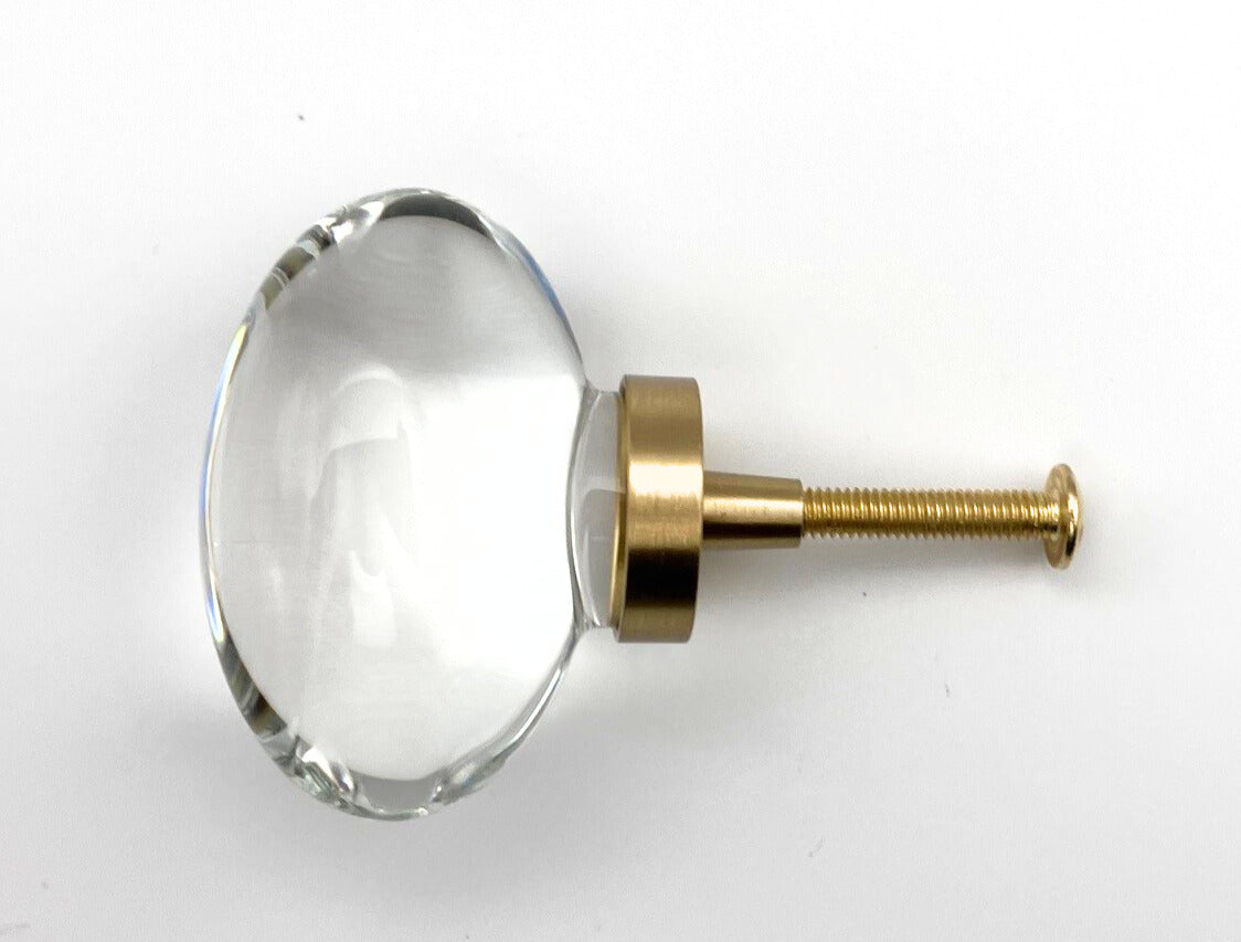 Clear glass knob with gold metal base on a white background