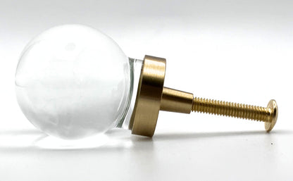Clear oval glass knob with gold base on a white background