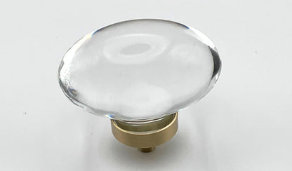 Clear oval glass knob with gold base on a white background