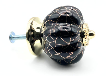 Decorative black and gold knob on a white background