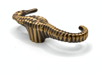 Bronze seahorse-shaped knob on a white background