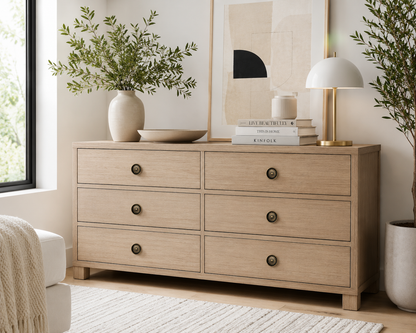 Bronze sunburst cabinet knobs installed on a modern light oak dresser in a bright Scandinavian-inspired room.