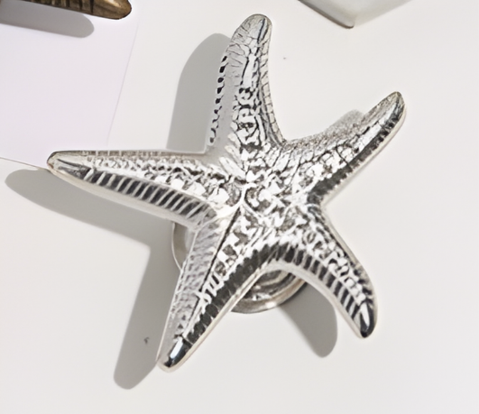 Silver starfish-shaped object on a white surface