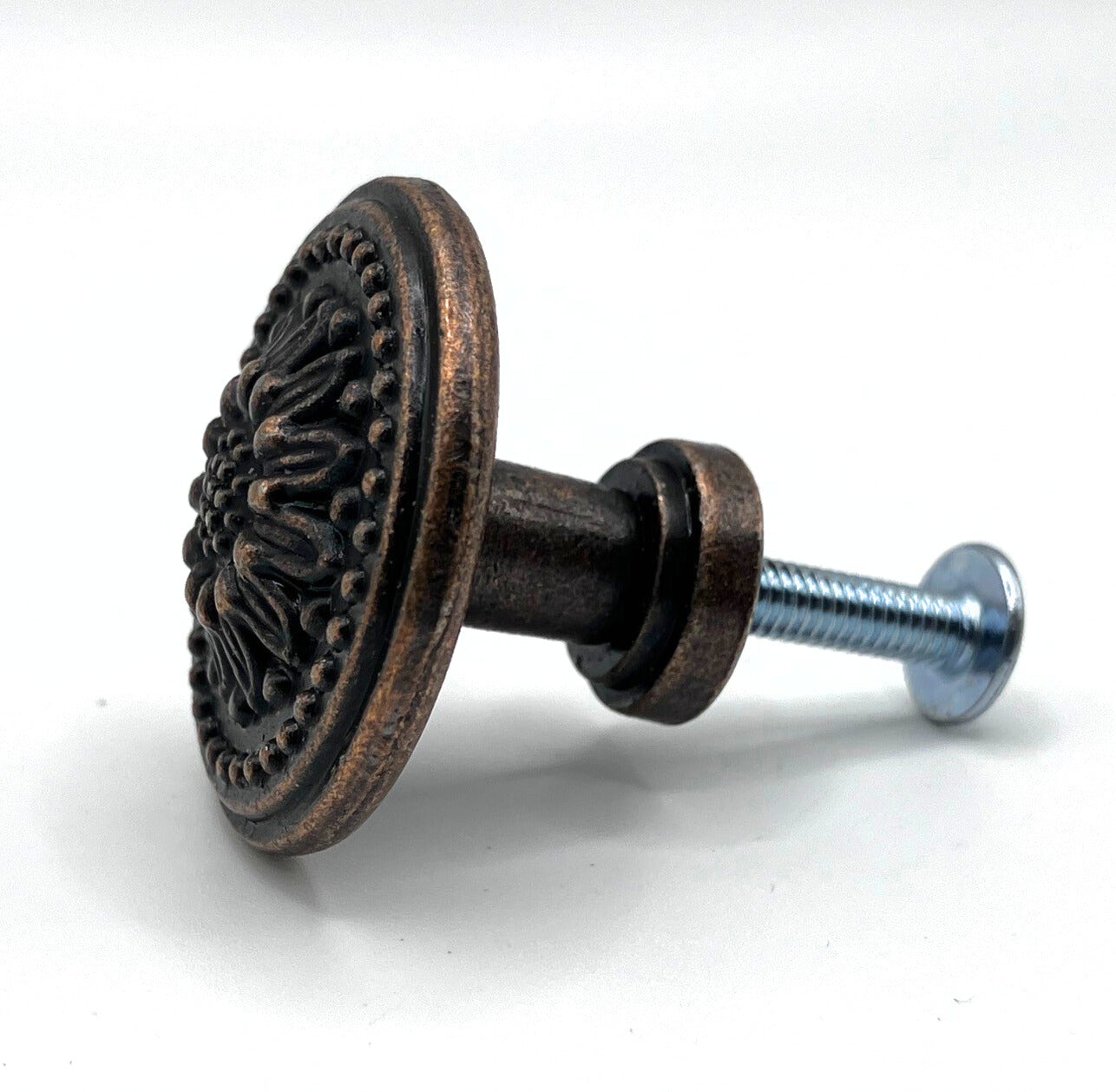 Decorative metal knob with intricate design on a white background