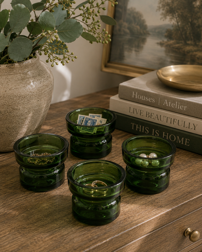 Vintage green Dansk glass holders repurposed as bathroom organizers for cotton balls and small accessories.