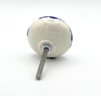 White ceramic knob with blue and red design on a white background