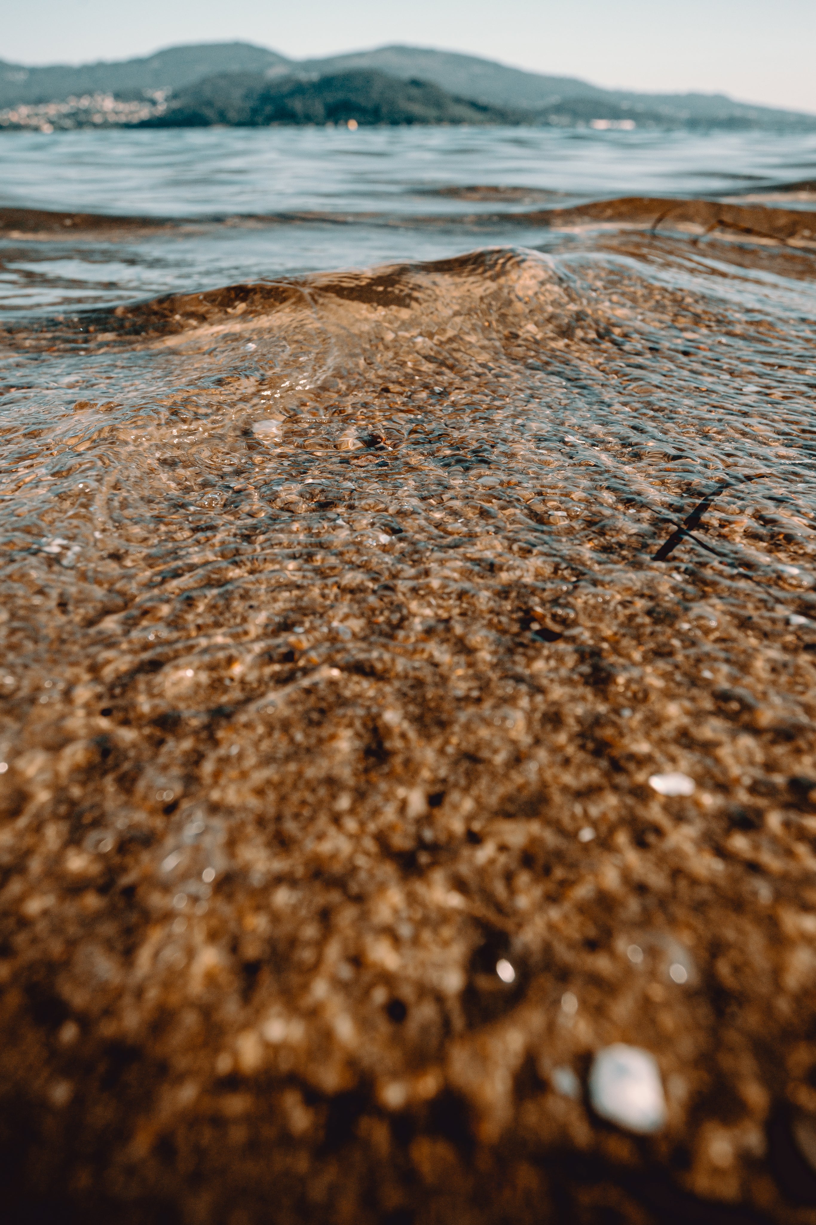 Clear ocean water running over the beach sand/rocks/shells