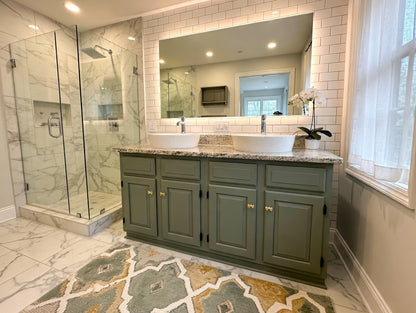 Bathroom with green vanity, large mirror, and shower area.