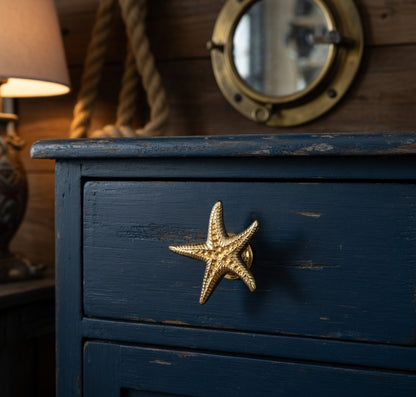 Blue wooden drawer with a starfish-shaped handle, surrounded by nautical decor.